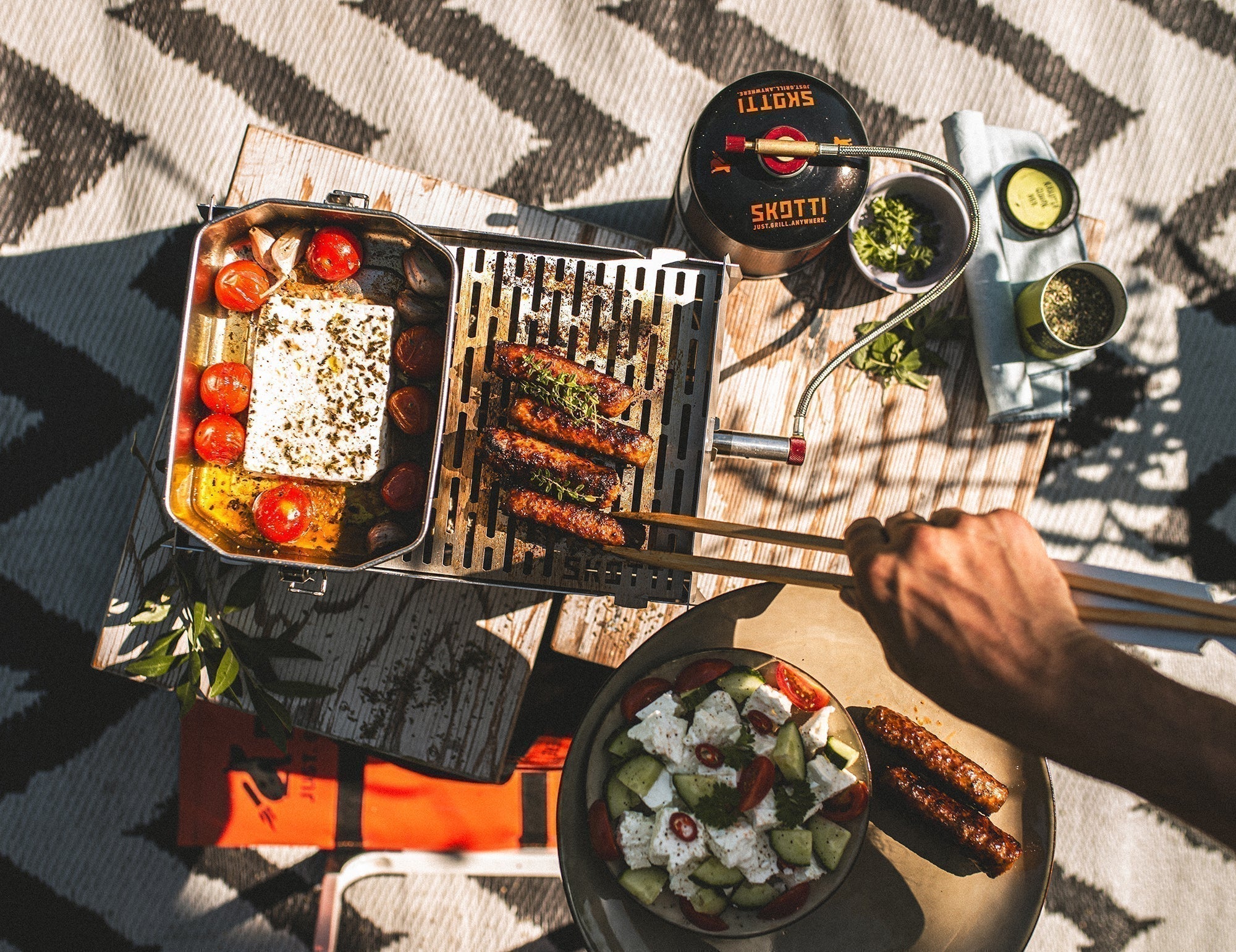 Skotti Outdoor grillen mit Backfeta in der BOKS und Würstchen auf dem Grill